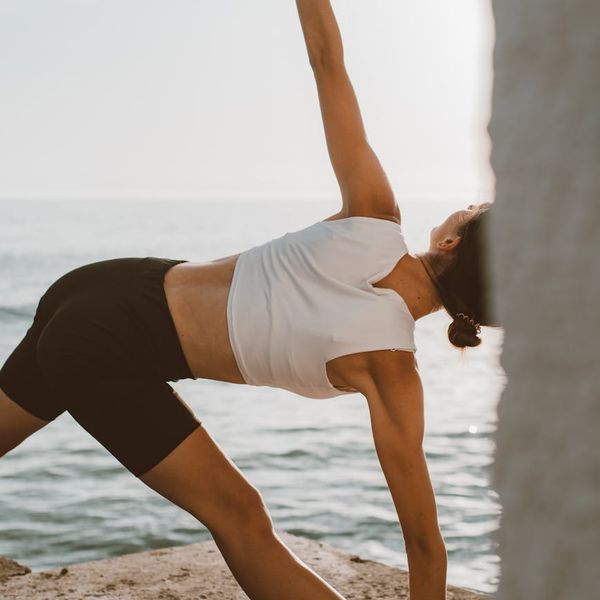 Person stretching gently outdoors during sunrise, feeling energized.